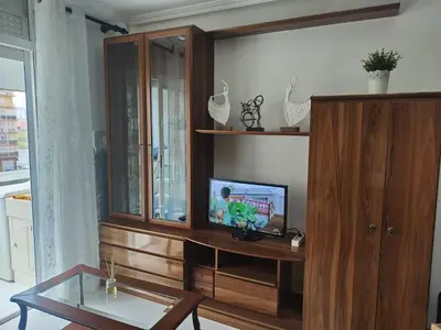 a living room with a tv and a wooden cabinet at EnFOZ SuperAlojamiento Entre Playas in Foz