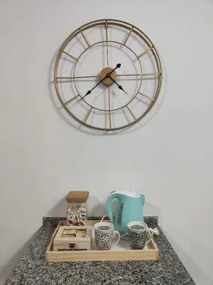 a clock on a wall above a tray with cups at EnFOZ SuperAlojamiento Entre Playas in Foz