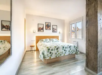 a white bedroom with a bed and a window at Nômada Castillo _ VUT-LE-251 in Ponferrada