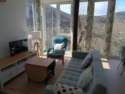 a living room with a couch and a tv at O Salgueiral in Castro Caldelas