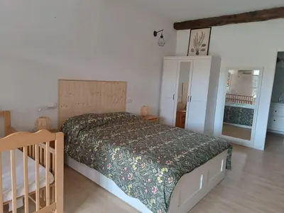 a bedroom with a bed and a crib in a room at O Salgueiral in Castro Caldelas