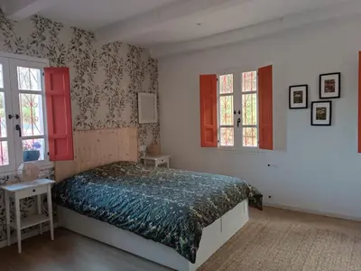 a bedroom with a bed and two windows at O Salgueiral in Castro Caldelas