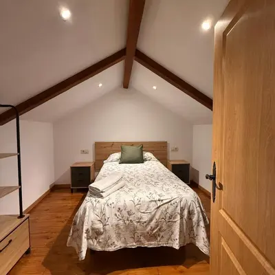 a bedroom with a bed with a green pillow on it at A Barreira in Ferrol