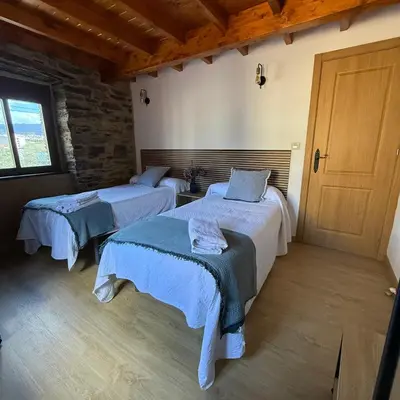 a bedroom with two beds and a door at A Barreira in Ferrol