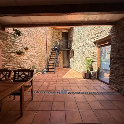 a patio with a wooden bench and a brick wall at A Barreira in Ferrol