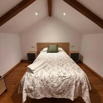 a bedroom with a bed with a green pillow on it at A Barreira in Ferrol