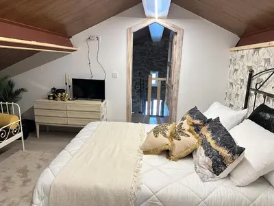 a bedroom with a white bed and a tv at El nido del cuco in Padrón