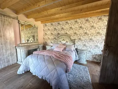 a bedroom with a bed and a wall with wallpaper at El nido del cuco in Padrón