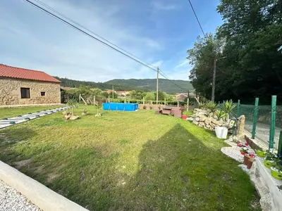 a yard with a grassy yard with a fence and a building at El nido del cuco in Padrón