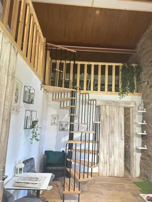 a wooden spiral staircase in a living room at El nido del cuco in Padrón