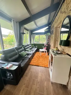 a living room with a black leather couch at El nido del cuco in Padrón