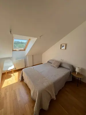 a bedroom with a large bed with a window at PortoHome 1 in Portomarin