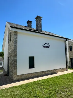 a large white building with a sign on it at PortoHome 1 in Portomarin