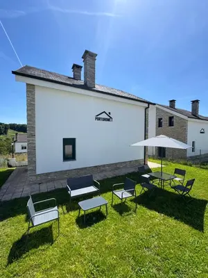 a group of chairs and tables with umbrellas in a yard at PortoHome 1 in Portomarin