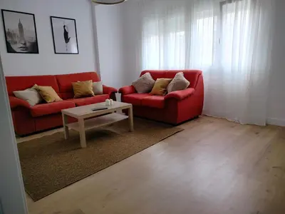 a living room with a red couch and a coffee table at Altamira in Viveiro