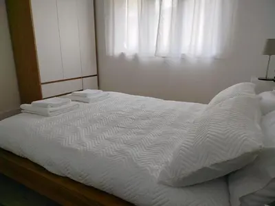 a bedroom with a white bed with a window at Altamira in Viveiro