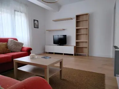a living room with a red couch and a table at Altamira in Viveiro