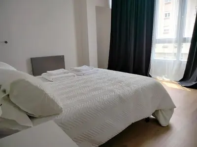 a bedroom with a bed with white sheets and a window at Altamira in Viveiro