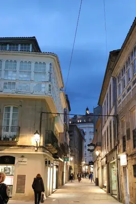 a city street with buildings and people walking down a street at Delta in Monforte de Lemos