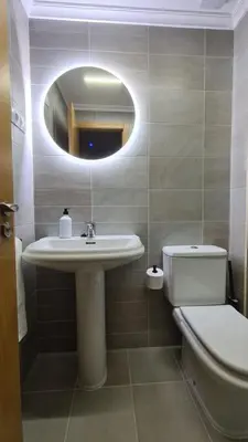 a bathroom with a sink and a toilet and a mirror at Piso Vega Foz in Foz