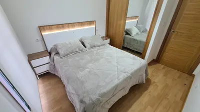 a small bedroom with a bed and a mirror at Piso Vega Foz in Foz