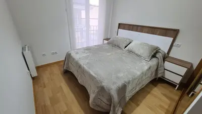 a bedroom with a bed with a wooden headboard at Piso Vega Foz in Foz