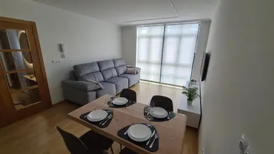 a living room with a table and a couch at Piso Vega Foz in Foz
