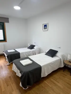 a room with two beds with towels on them at PortoHome 2 in Portomarin