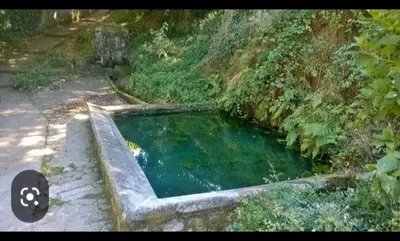 a pool of water on a road next to a field at PISO DEL PARQUE 2 in Santiago de Compostela