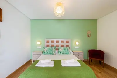 a bedroom with a large bed with two pillows at A Casa da Carminha, Ribeira Sacra in Pereiro de Aguiar