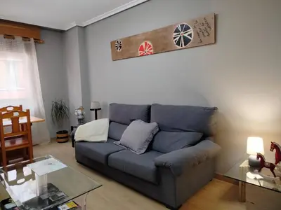 a living room with a blue couch and a glass table at PONFETEMPLE in Ponferrada