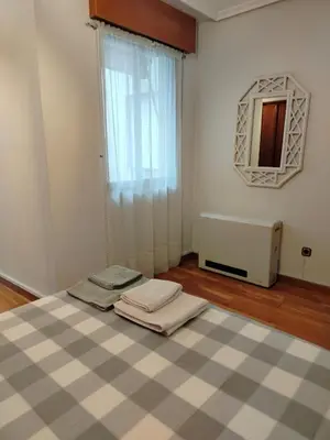 a room with a bed and a mirror and a window at PONFETEMPLE in Ponferrada