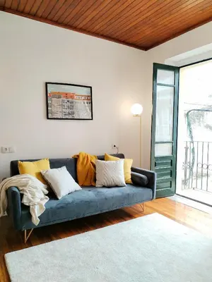 a living room with a blue couch with yellow pillows at Steve Apartamento in Viveiro