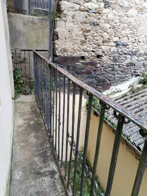 a iron fence in front of a stone wall at Steve Apartamento in Viveiro