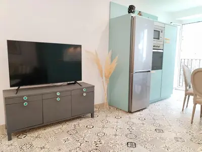 a living room with a tv and a refrigerator at Steve Apartamento in Viveiro