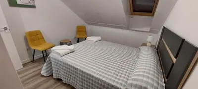 a bedroom with a bed and two yellow chairs at Temple I in Ponferrada