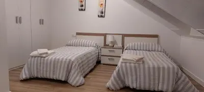 a bedroom with two beds with striped sheets at Temple I in Ponferrada