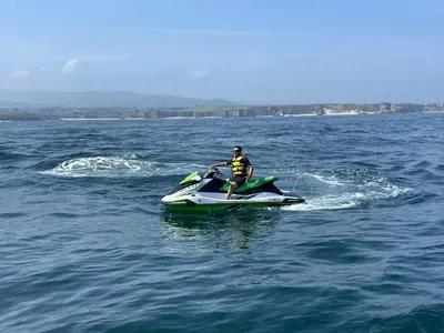a man riding a jet ski in the water at Casa Fernanda Viavélez in El Franco