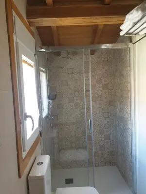 a bathroom with a glass shower with a toilet at Casa Larán in Chantada
