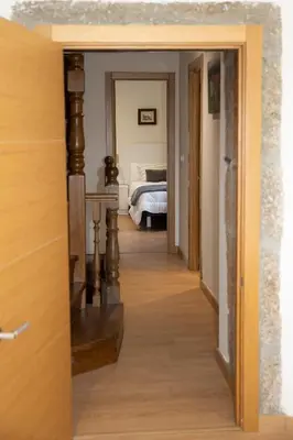 a hallway leading to a bedroom with a bed at Casa Larán in Chantada
