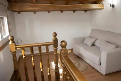 a living room with a couch and a stair case at Casa Larán in Chantada