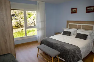 a bedroom with a large bed and a window at Casa Saborido in Chantada