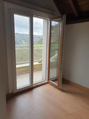 an empty room with a sliding glass door with a balcony at Casa Saborido in Chantada