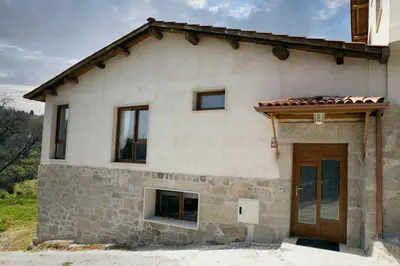a stone house with a wooden door at Casa da Cocha in Chantada