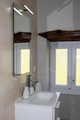 a white bathroom with a sink and a mirror at Casa da Cocha in Chantada