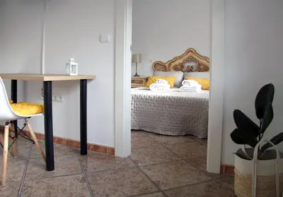a bedroom with a bed with a table and a desk at La casita de Fide in Molinaseca