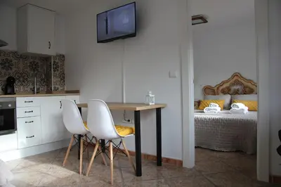 a kitchen with a table and two chairs and a bed at La casita de Fide in Molinaseca