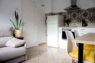 a living room with a table and a kitchen at La casita de Fide in Molinaseca