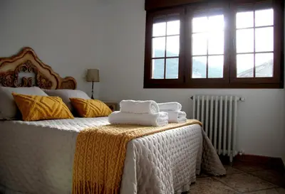 a bedroom with a bed with towels on it at La casita de Fide in Molinaseca
