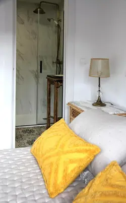 a bedroom with a bed and a glass shower at La casita de Fide in Molinaseca